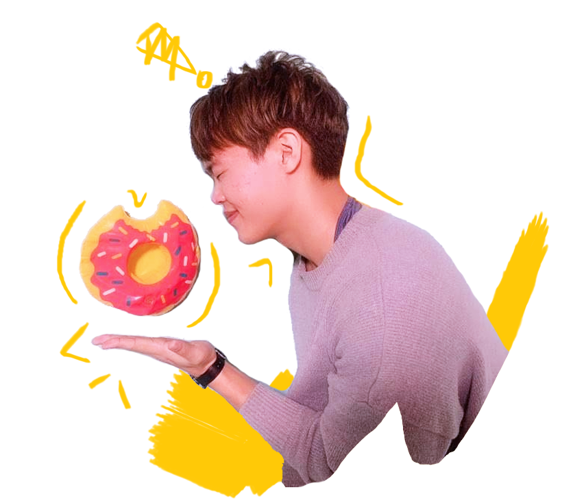 A smiling Korean American man holding a plastic donut.