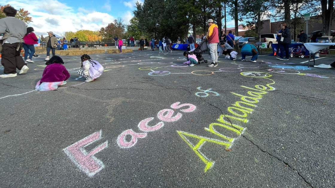 An empty parking lot with children using chalk to color in faces.